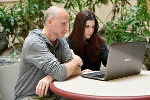 Benjamin and Siler looking at computer