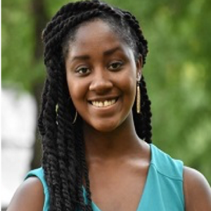 Head shot of Mahogony Monette against greenery background